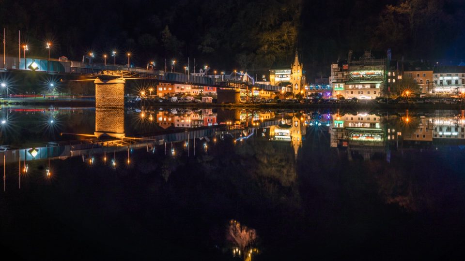 Traben-Trarbach bei Nacht – Brückentor, Grevenburg und das Banner des Mosel-Wein-Nachts-Markts spiegeln sich in der Mosel